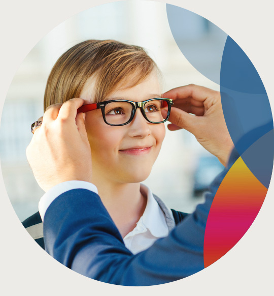 An optician places a new pair of glasses on a child.