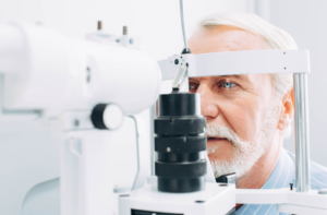 An older man getting his eyes examined for diabetes with an optometrist
