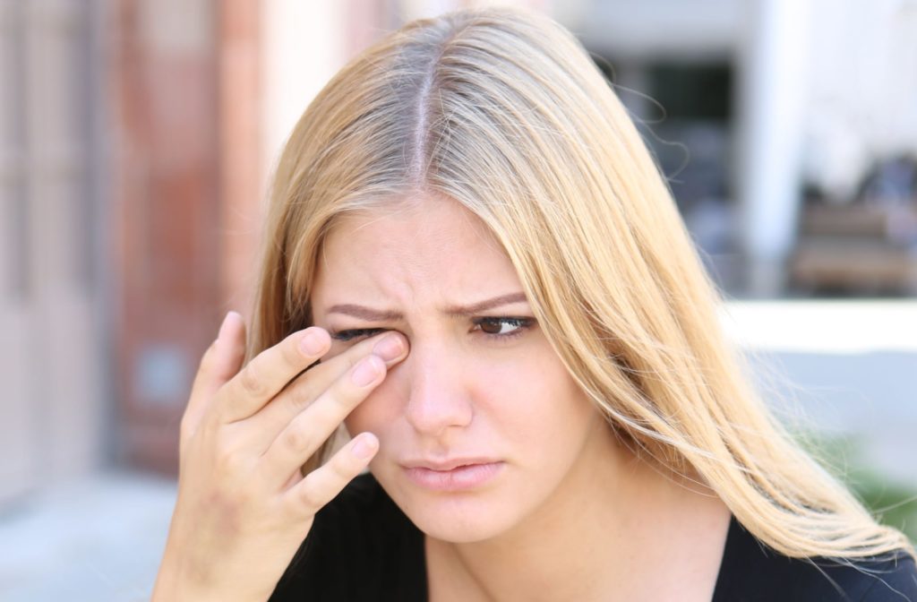 A woman rubs her eyes due to eye pain and itchiness