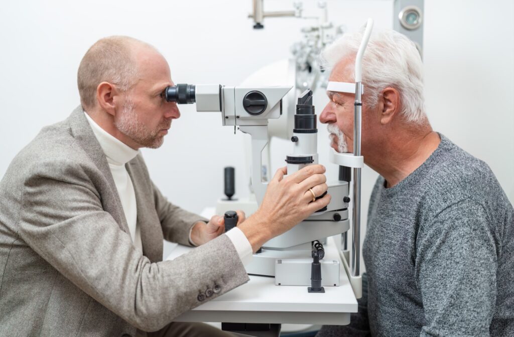 An optometrist uses a slit lamp to carefully examine their senior patient's eyes during a routine eye exam.