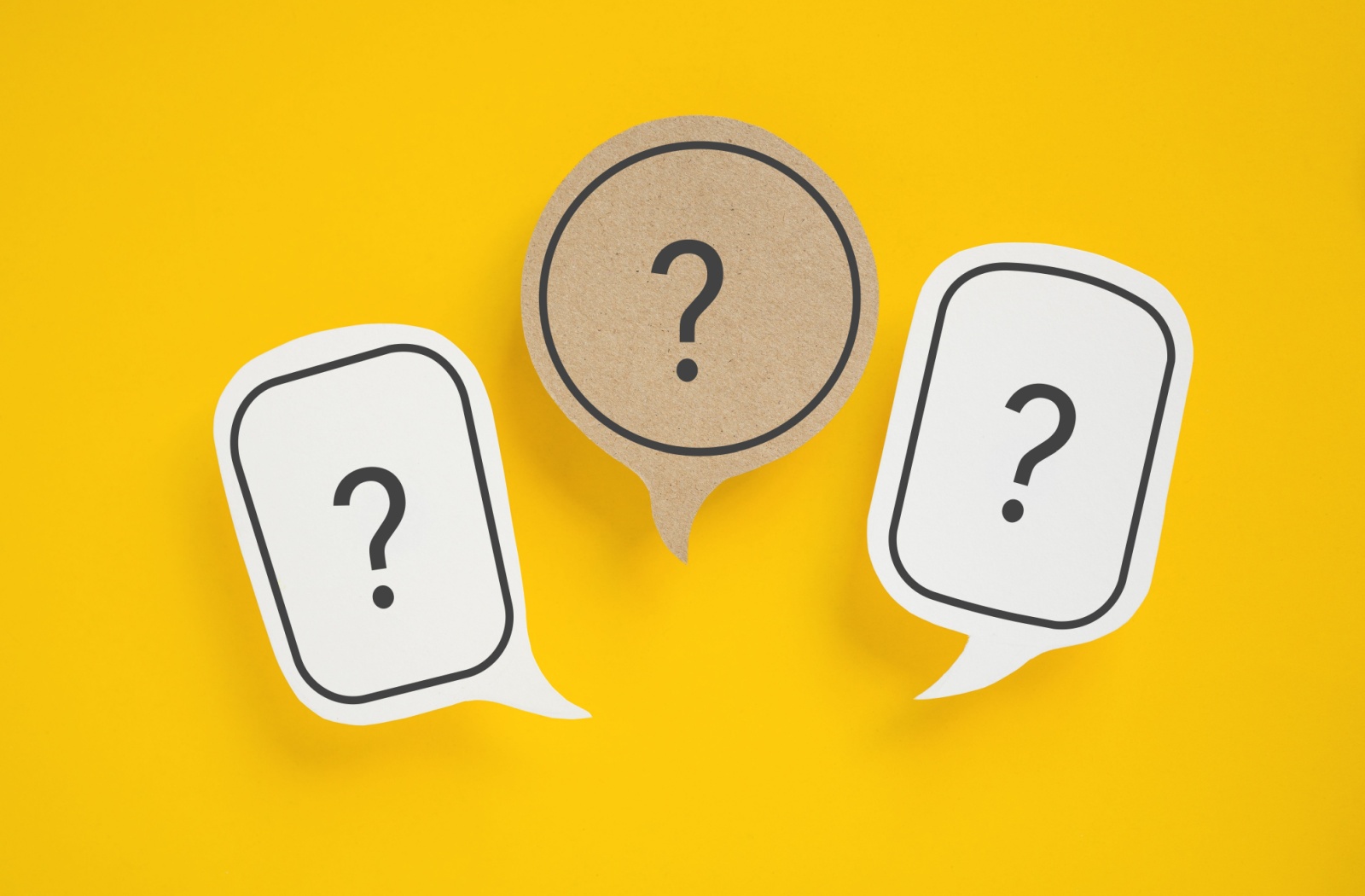 Three speech bubbles are arranged on a yellow background. Each bubble has a single question mark in the centre.