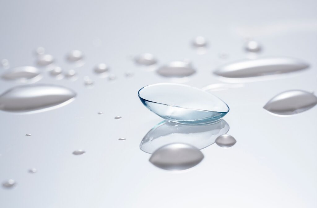 Close-up of a flexible contact lens amid water droplets.